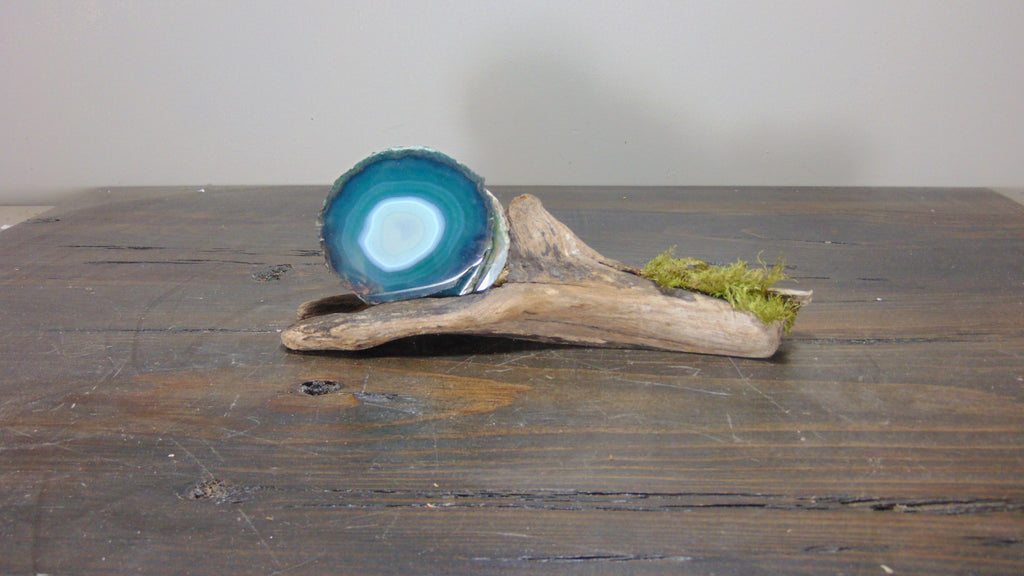 Green agate coaster with driftwood coaster holder on brown table
