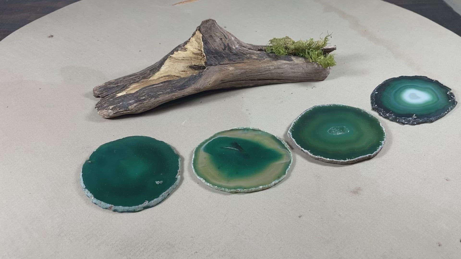 Video showing a 360 degree view of four green agate coasters with driftwood coaster holder